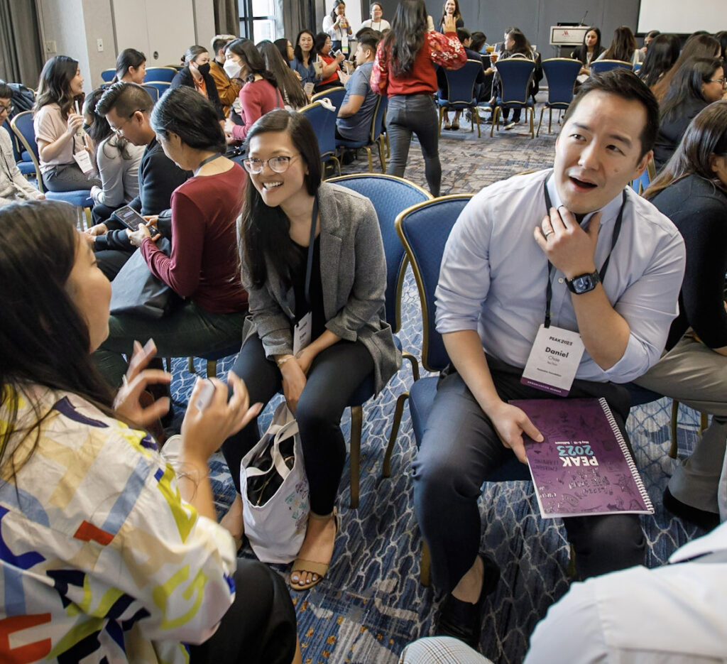 A room full of AANHPI Caucus members gather and converse at PEAK2023 in Baltimore