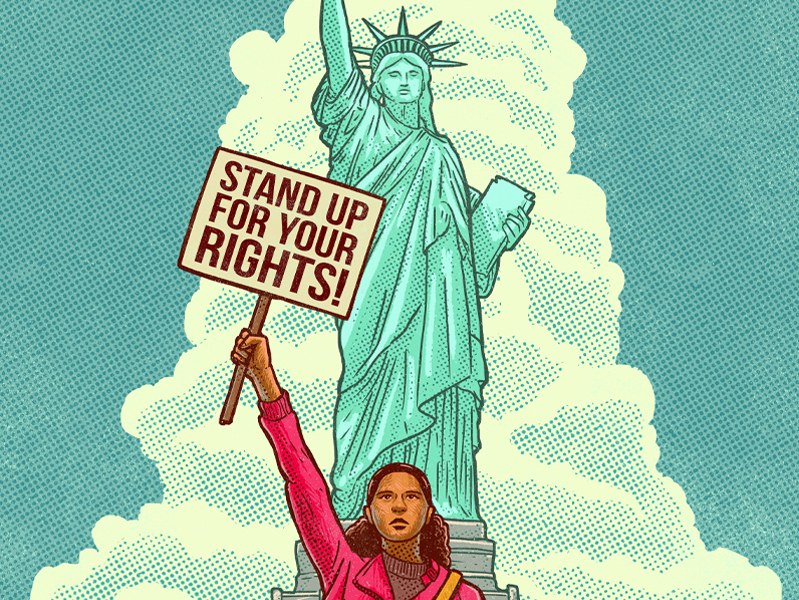 A young Brown girl holds a sign that reads "Stand up for your rights" in front of the statue of liberty