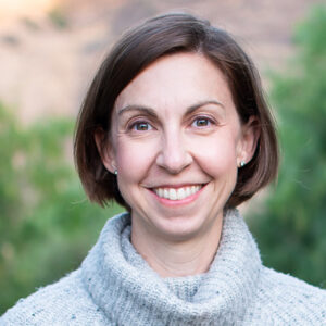 Allison Gister smiles in her headshot picture, with her short brown hair tucked behind her ears