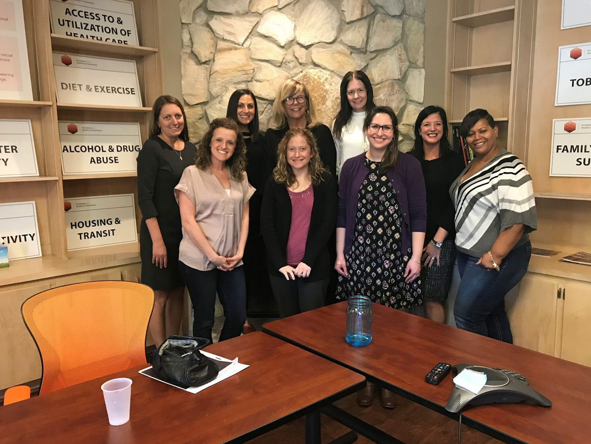 9 PEAK Florida members pose for a photo at a lunch and learn.