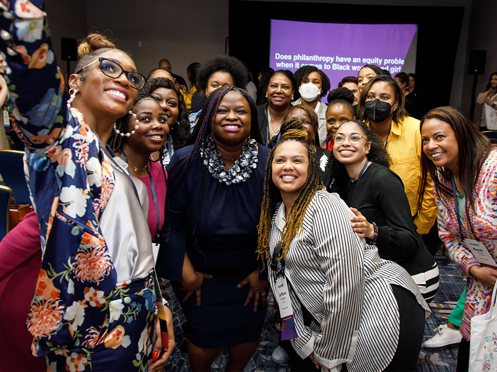 A group of Black women gathered at a PEAK event smiling and taking a selfie