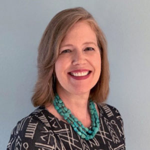 Ellen is wearing a turquoise necklace and a patterned shirt